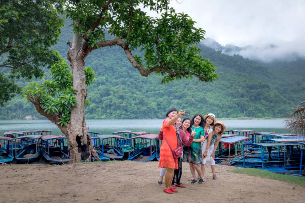 los turistas están disfrutando y feliz tomar autorretratos en el muelle en el turístico lago de ba ser resort en la provincia de bac kan, vietnam - ba kan fotografías e imágenes de stock