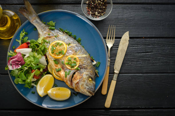 istock Grilled Dorado with lemon, thyme, rosemary and fresh salad. Copyspace. 1014697470