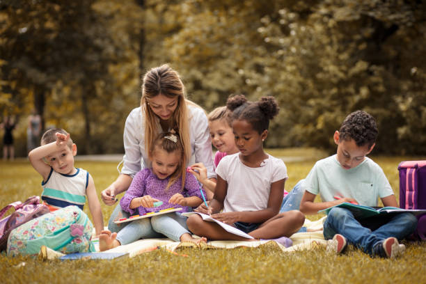 istock Learning and have fun. Happy children with teacher. 1014698370