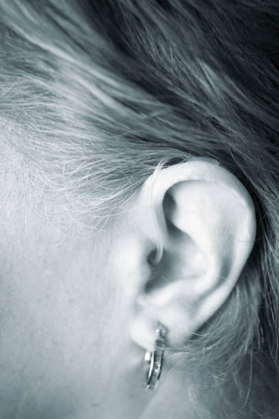 istock Deaf lady with modern technology digital hearing aid in her ear. 1014703242