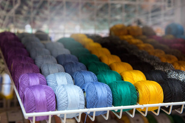 Multicolored tangles of thread on the shelf in the store. Yellow, green, blue,\n  light blue, violet.