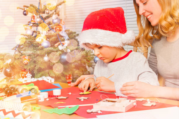 istock Little boy decorating Christmas ornaments with mom 1014712468