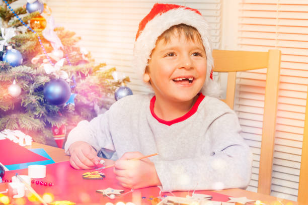 istock Cute boy making own Christmas ornaments at home 1014715710