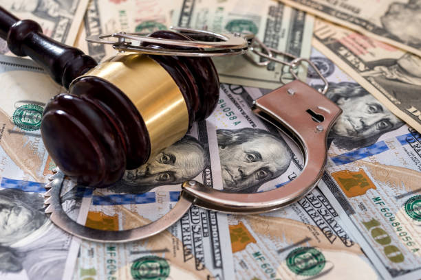 istock Steel handcuffs with judge's gavel on dollar banknotes 1014716240