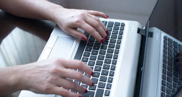 istock Secretary typist typing on laptop computer keyboard 1014719704