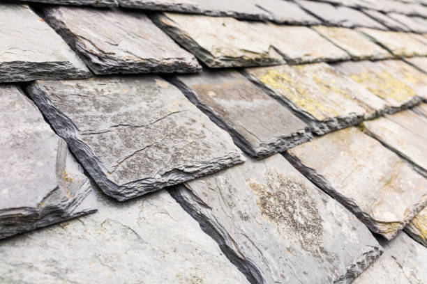 Close-up of traditional slate roof tiles, worn and weathered but still in good working condition on a British house.