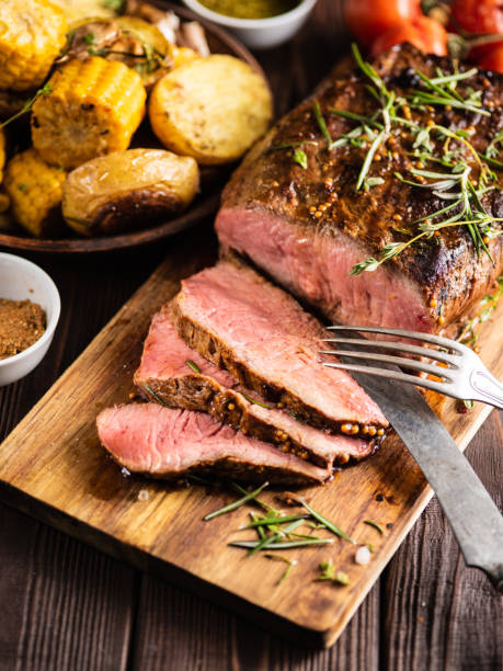 istock Sliced Roast beef on cutting board with grilled vegetables . 1014729000