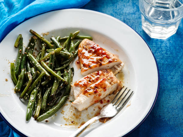 istock Barbecue chicken fillet on a white plate with grilled green beans. 1014730130