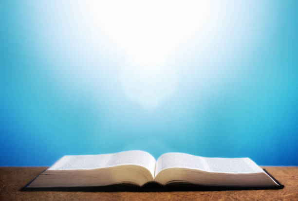 Bible in bright sunlight against the sky An open copy of the Bible lit by extremely bright sun in the sky. bible open stock pictures, royalty-free photos & images
