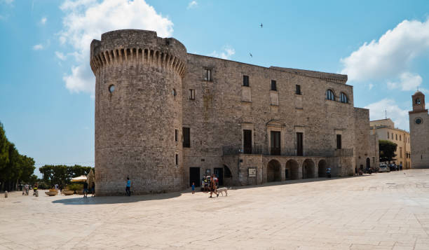 Norman castle of Conversano with people. Conversano,Italy,08/04/2018; unrecognizable people a sunny summer morning,in the square of center town of Conversano,under the castle,while are in their daily life. conversano stock pictures, royalty-free photos & images