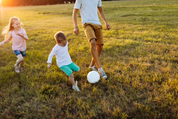 istock Kids playing soccer with father 1014754504