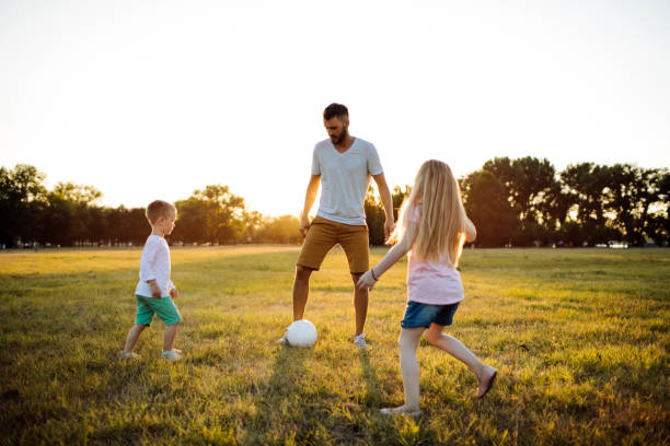 istock Father playing soccer with kids 1014754712