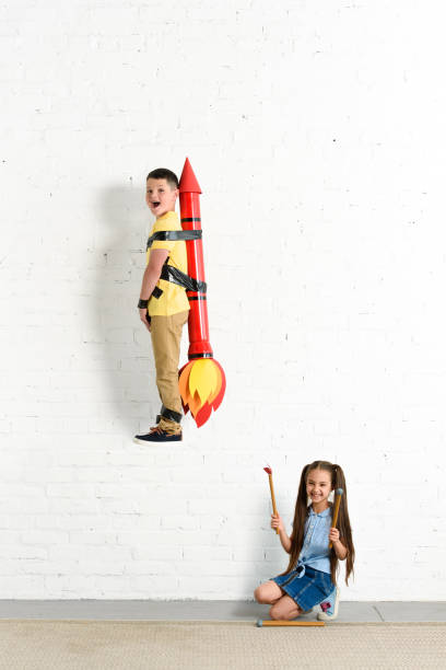 istock sister pretending setting on fire toy rocket with brother at home 1014757190