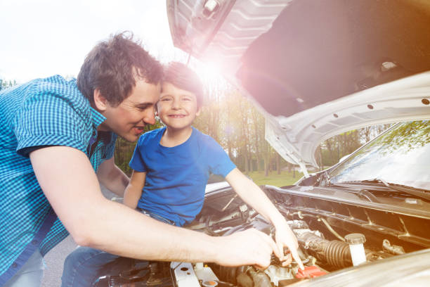 istock Young father teaching his little son repairing car 1014763172