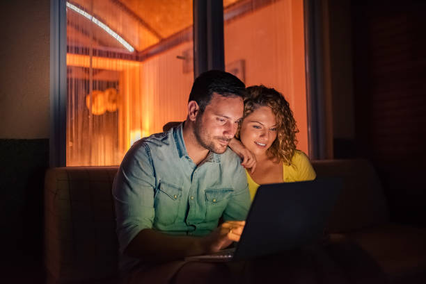 istock Young couple looking using laptop at night. Cozy enviroment. 1014770974