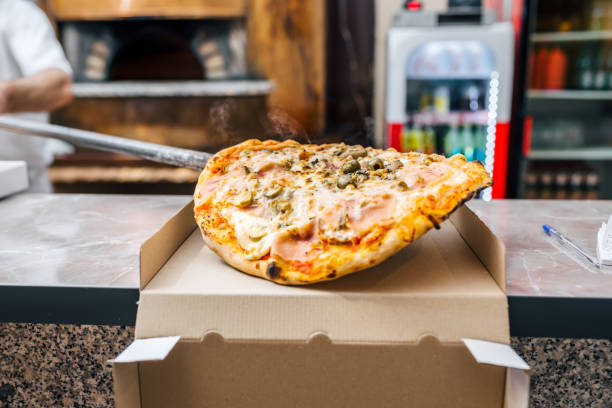 istock Chef putting fresh baked pizza in box for take away. 1014771156