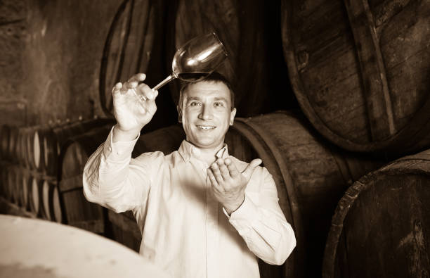 istock man with glass of wine in winery cellar 1014773648