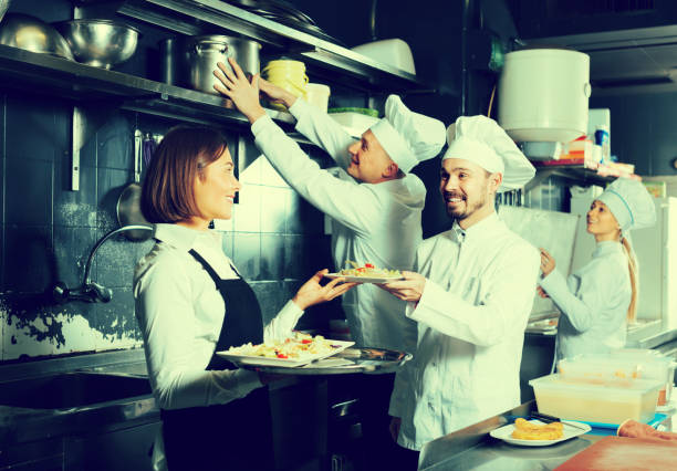istock Cheerful female waiter taking ordered dishes 1014773886