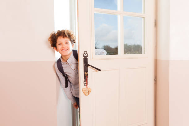 Happy schoolboy looking through the doorway