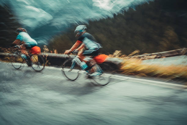 Slow motion photo of a two sportsmans riding bicycles Slow motion photo of a two sportsmans riding bicycles, cycling championship in Alpine mountains, active sportive lifestyle slow motion photos stock pictures, royalty-free photos & images