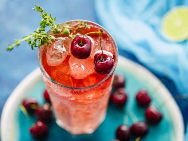 istock Iced organic cherry lemonade with fresh berries and thyme on the blue table. 1014785106
