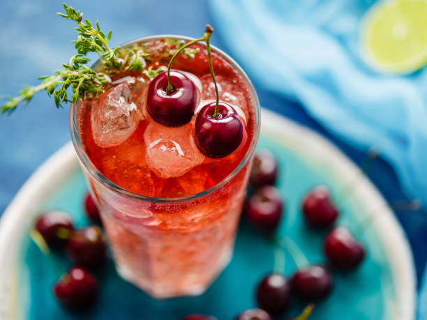 istock Iced organic cherry lemonade with fresh berries and thyme on the blue table. 1014785178