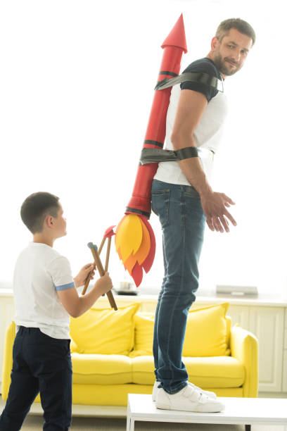 istock disobedient son playing with tied father with rocket toy on back at home 1014790826