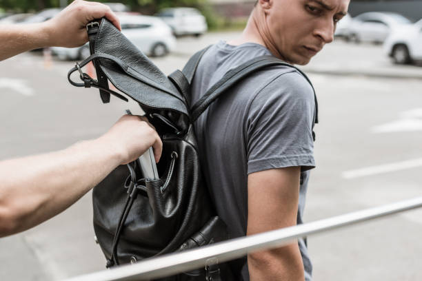 istock robbery pickpocketing laptop from mans backpack on street 1014799068