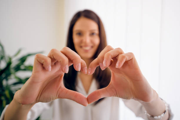 istock Young woman showing heart-shaped symbol 1014801710