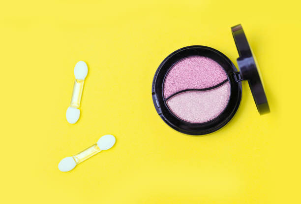 istock Eye shadows pallets and applicators on yellow background. 1014802018