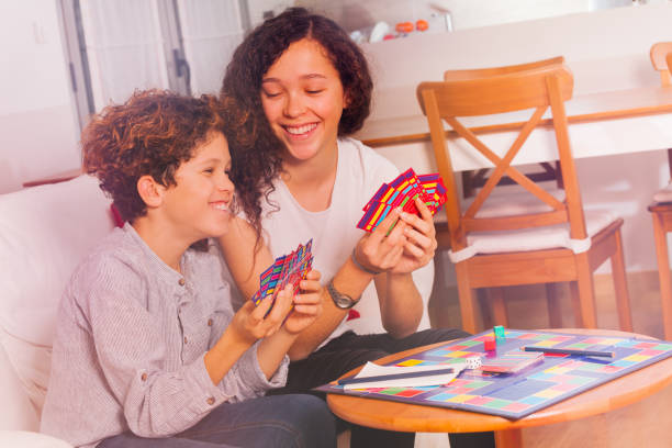 lindo menino e menina se divertindo jogando jogo do tabletop - leisure games dice indoors table - fotografias e filmes do acervo
