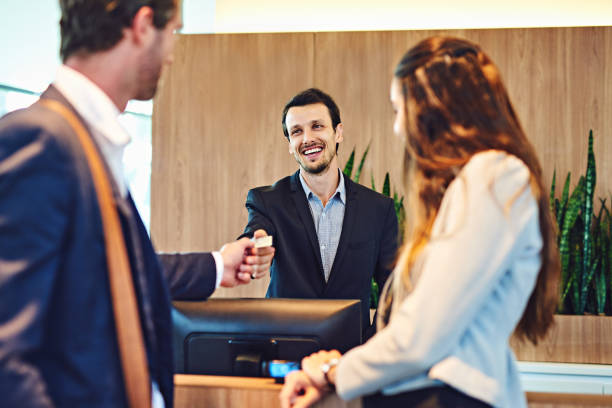 Time to pay for your stay Cropped shot of a businessman and businesswoman checking into a hotel point of sale photos stock pictures, royalty-free photos & images