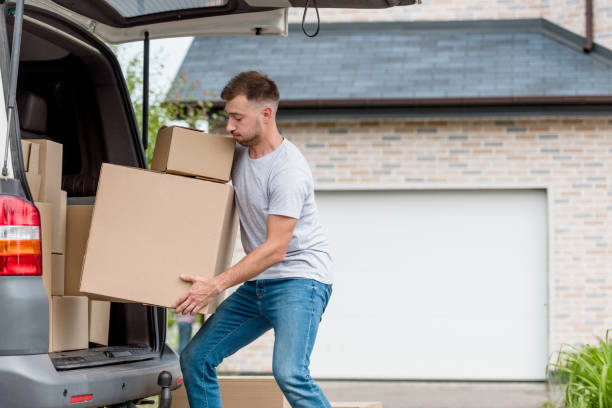 istock strenuous young man moving boxes from car into new house 1014814192