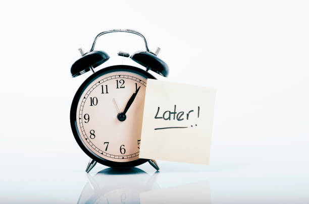 istock handwriting word LATER on yellow sticky paper and reflection on surface 1014814532
