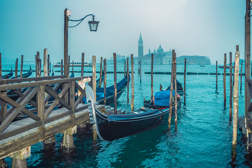 twilight scenery with gondola near pier from Venice, Italy
