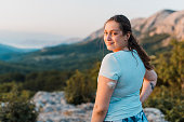 Woman with diabetes standing on top of the hill and looking at camera