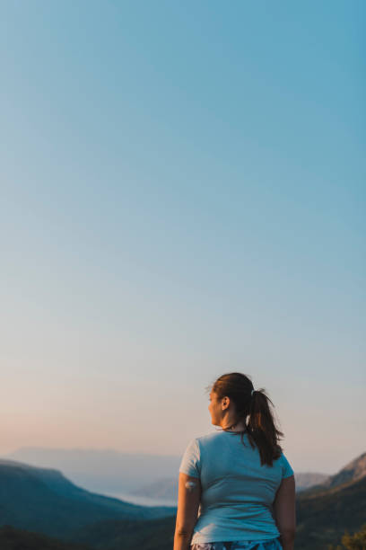 mujer con diabetes usando un sistema de monitoreo y admirando la vista continuos de la glucosa - ponytail brown hair tourist women fotografías e imágenes de stock