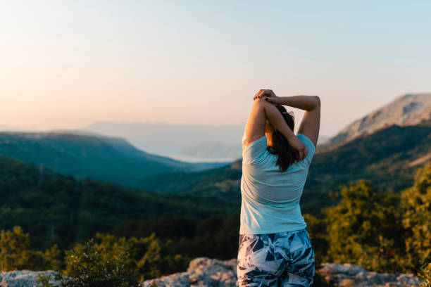 mujer con diabetes que se extiende sobre la colina - ponytail brown hair tourist women fotografías e imágenes de stock