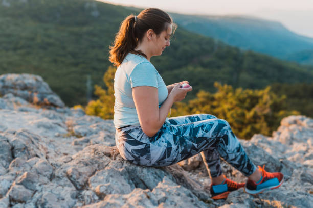 mujer con diabetes que usan su bomba de insulina - ponytail brown hair tourist women fotografías e imágenes de stock