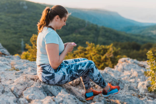 mujer con diabetes que usan su bomba de insulina - ponytail brown hair tourist women fotografías e imágenes de stock