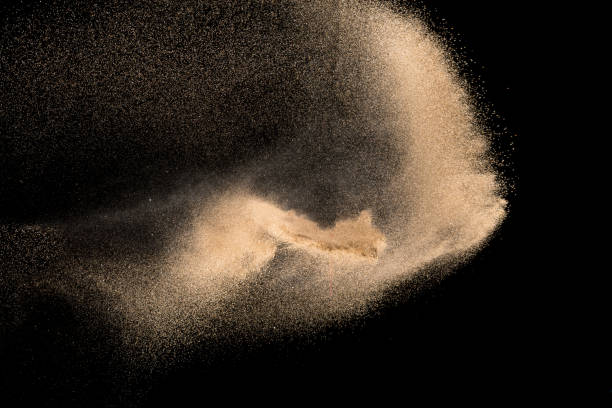 istock Dry river sand with stone explosion. Yellow colored sand splash against dark background. 1014822174