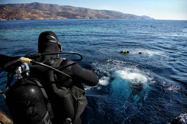 istock Divers jumping from the boat in water 1014824188