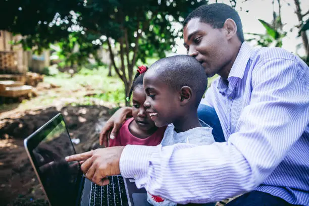 Happy african father,son  and daughter  with laptop