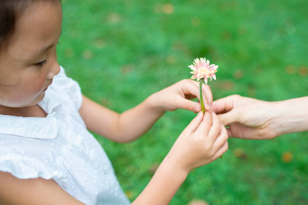 istock Parent and child handing flower 1014834690