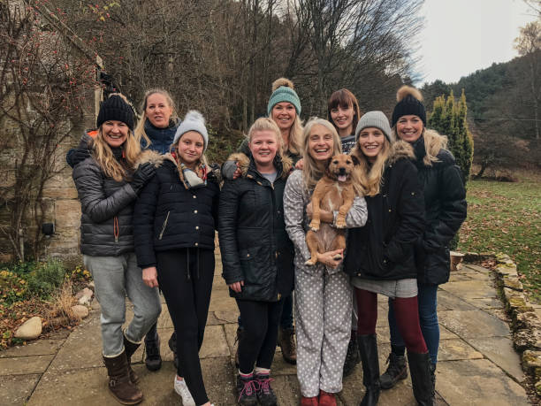 Women and Dog Ready for Christmas Walk Family of females are posing for a photo before going hiking in winter with their pet dog. log cabin photos stock pictures, royalty-free photos & images