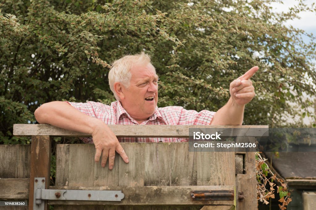 Mature man shouting and pointing over a fence - Royalty-free Vizinho Foto de stock