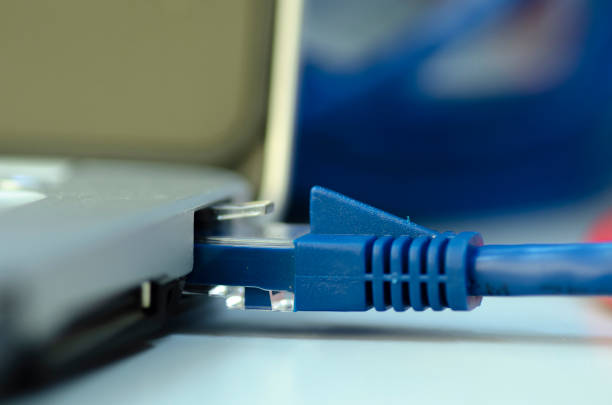 istock Closeup ethernet cable connected to the Lan port on laptop 1014848194