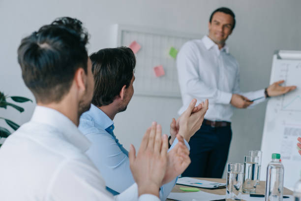 selective focus of colleagues applauding to mentor during business training in office selective focus of colleagues applauding to mentor during business training in office applaus stock pictures, royalty-free photos & images