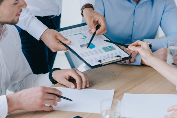 istock partial view of business people working on business plan at workplace in office 1014851492