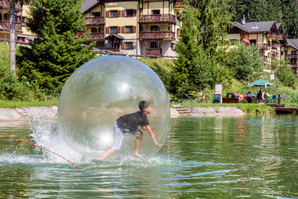 Young boy playing inside a floating water walking ball. stock photo